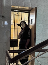 a man in a mask standing on a stairway